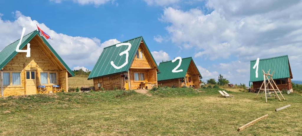 a couple of houses with numbers on their roofs at Markove kolibe 4, Uvac in Sjenica