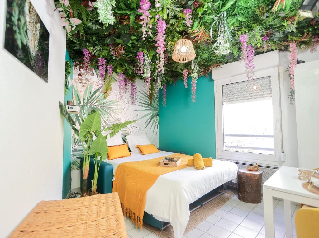 um quarto com duas camas e plantas no tecto em Jungle studio proche de la gare em Grenoble