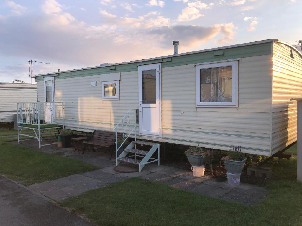 a mobile home with a porch and a staircase at Fantasy Island and Beach 6 Berth 545 in Ingoldmells