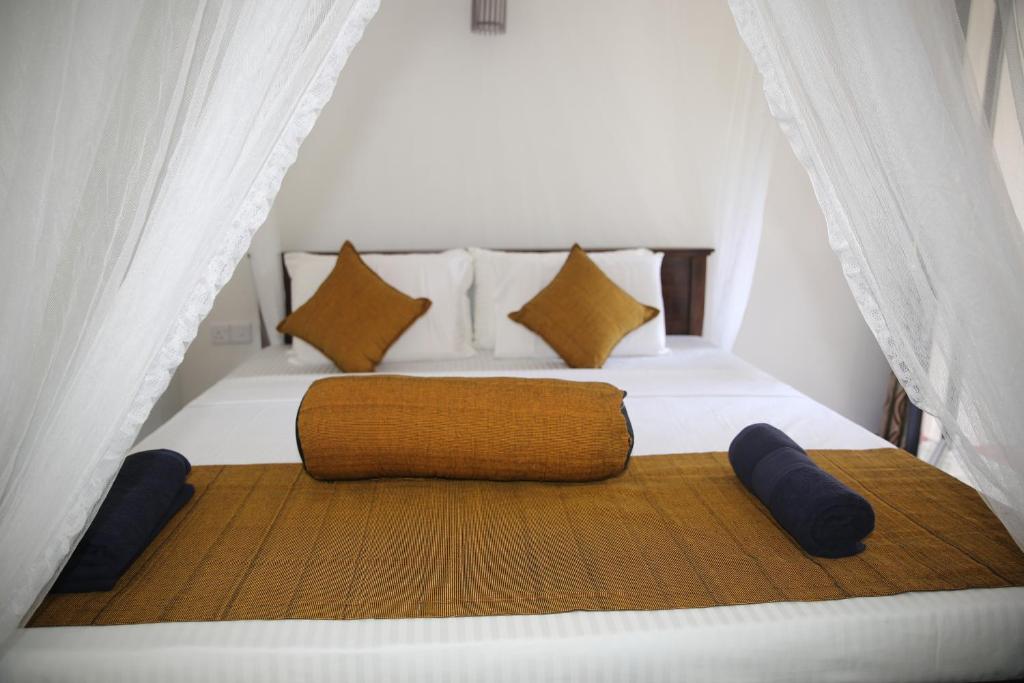 a bedroom with a large bed with two pillows at Rawana Mountain View in Ella