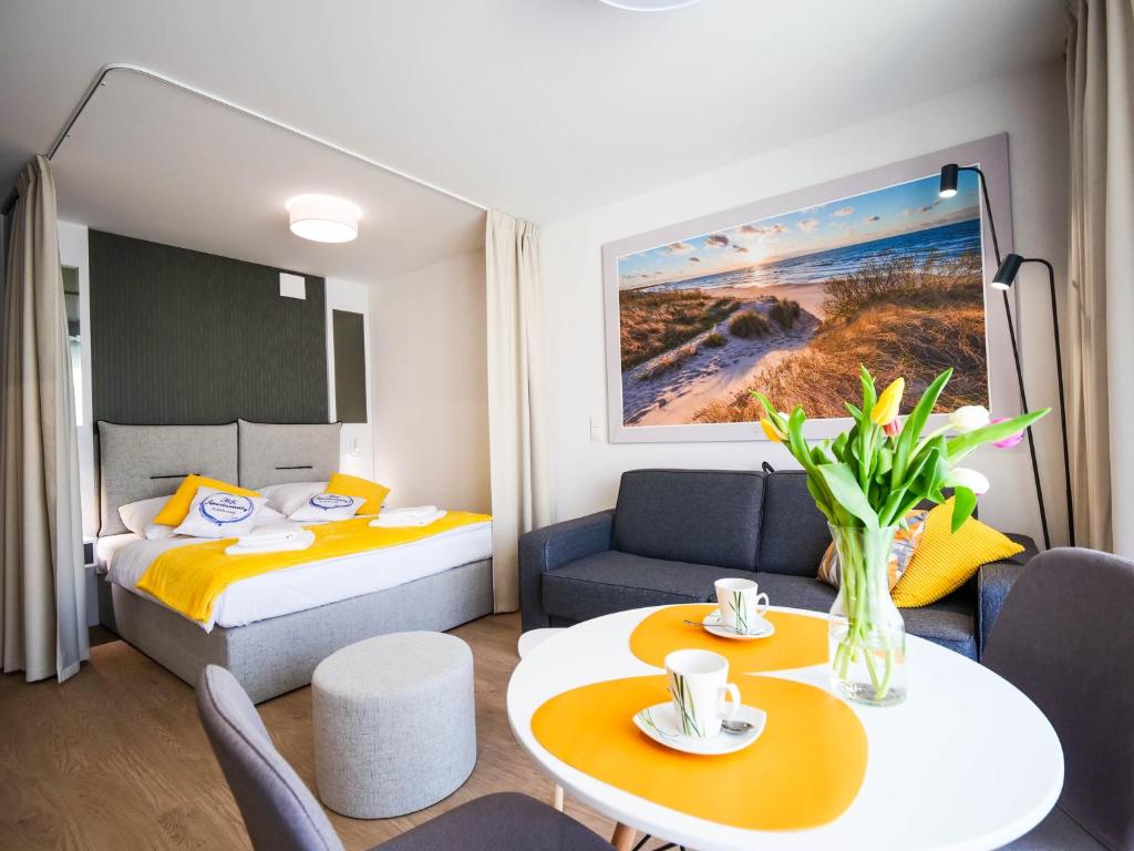 mały pokój hotelowy z łóżkiem i stołem w obiekcie MK Apartamenty Młyńska 10 w Kołobrzegu