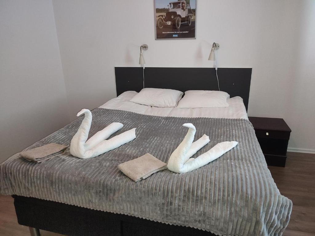 dos cisnes sentados sobre una cama en Burning Bridge Motell & Vandrarhem, en Götene