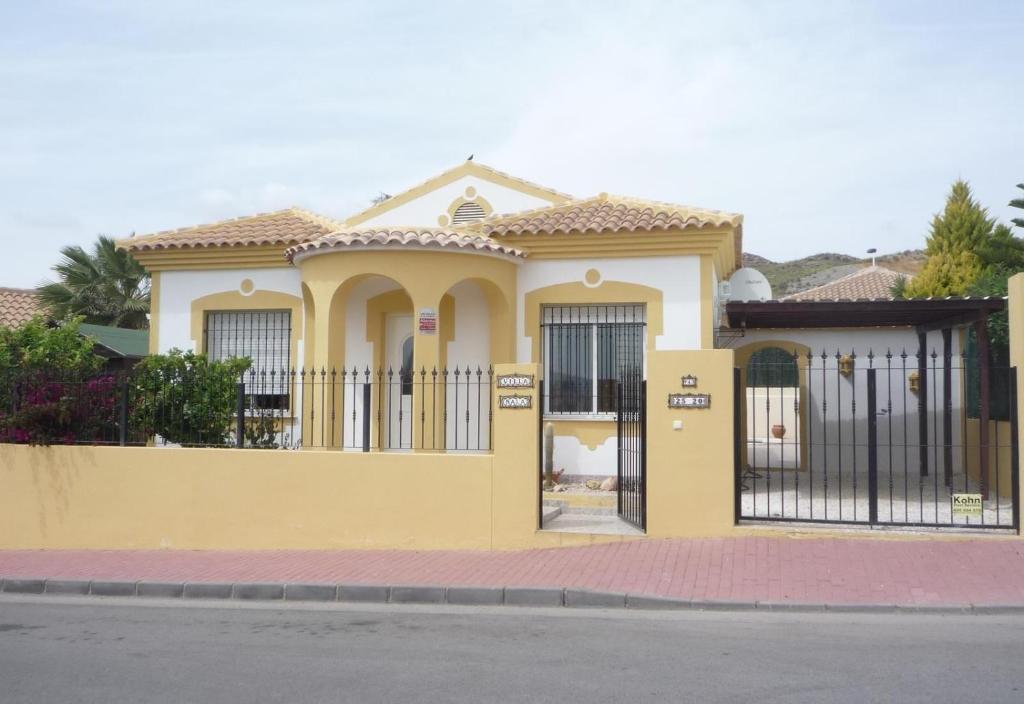 una casa gialla con un cancello davanti di Villa Nala a Mazarrón