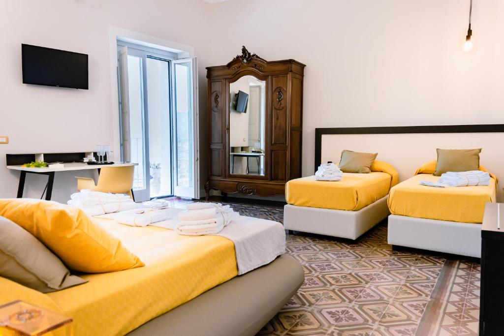 a hotel room with two beds and a mirror at Dimora Cavour in Amantea