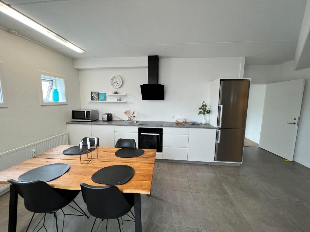 a kitchen with a table and chairs and a refrigerator at Agata Inn in Frederikssund