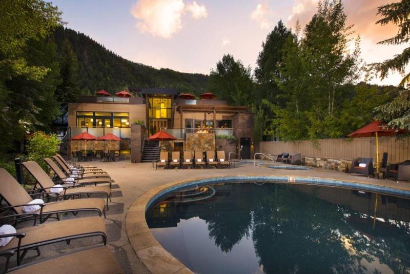 una casa con piscina frente a una casa en Luxury 1 Bedroom Downtown Aspen Vacation Rental With Access To A Heated Pool, Hot Tubs, Game Room And Spa en Aspen
