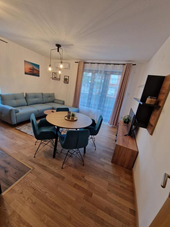 uma sala de estar com uma mesa e um sofá em Nina Apartman 2 em Soko Banja