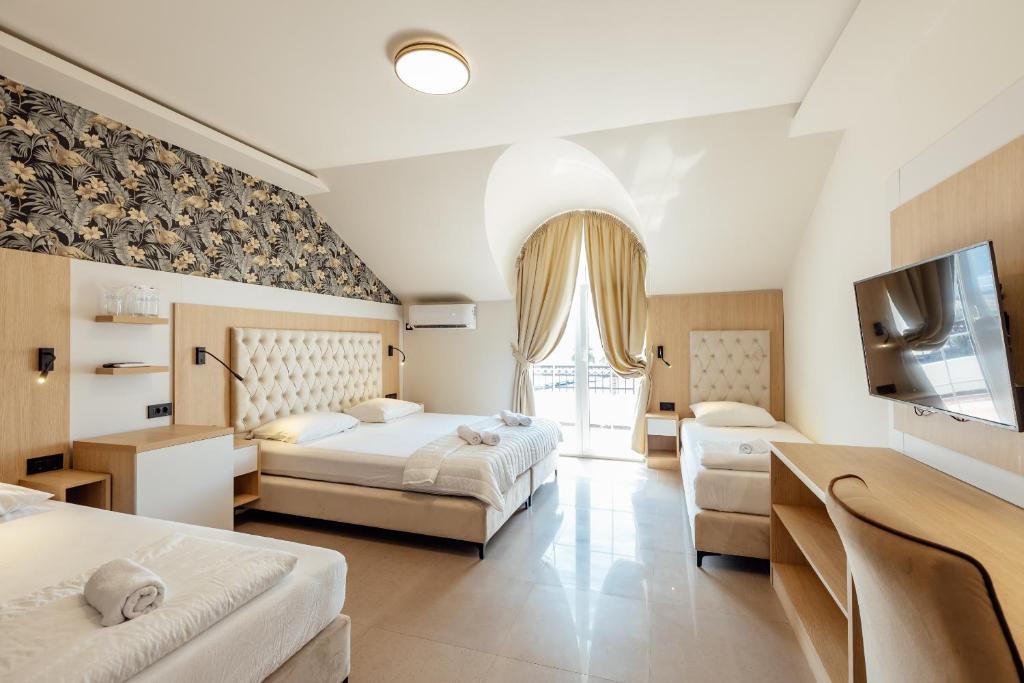 a hotel room with two beds and a flat screen tv at Apartments Belani Zelenika in Španjola
