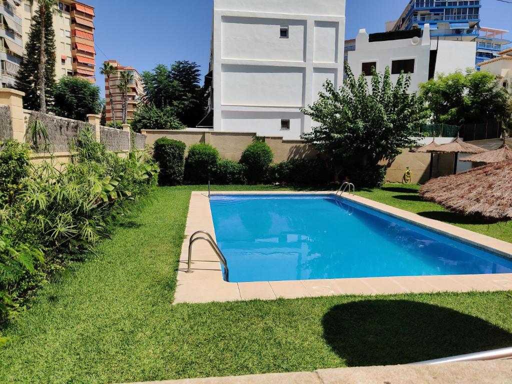 een zwembad in de tuin van een gebouw bij Apartamento a 50 metros de la playa Muchavista in El Campello