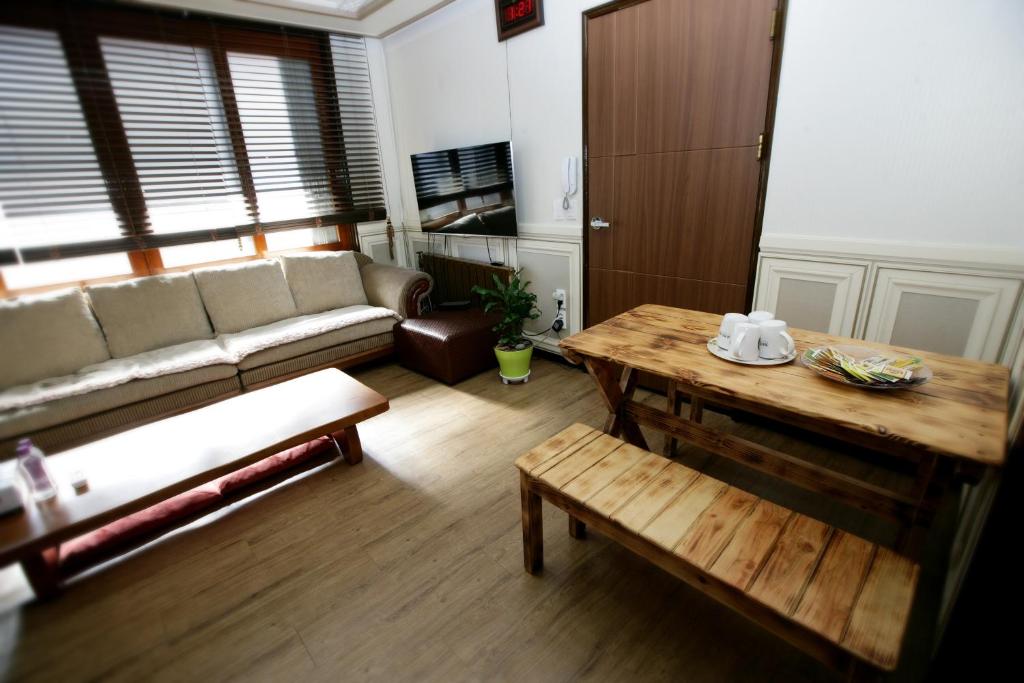 a living room with a couch and a table at Green Guesthouse in Gwangju