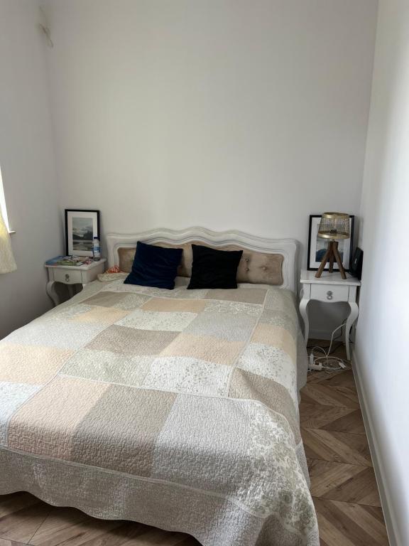 1 dormitorio con 1 cama grande y 2 mesas en Uroczy apartament z ogrodem, en Rumia