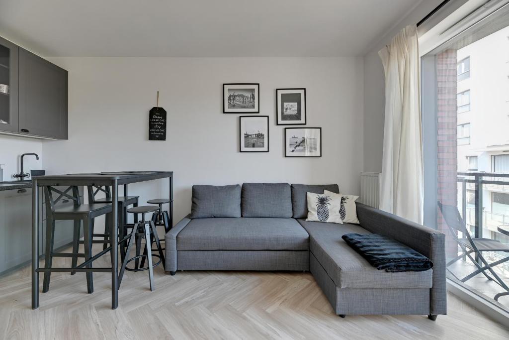ein Wohnzimmer mit einem Sofa und einem Tisch in der Unterkunft Bastion Wałowa Comfort Apartments in Danzig