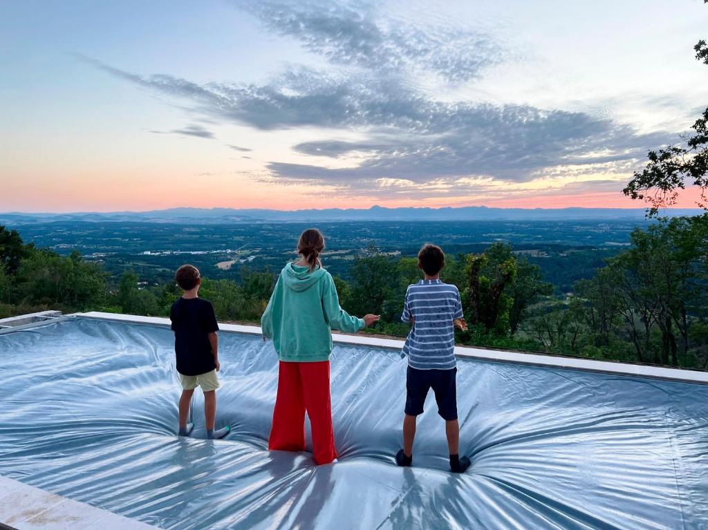 a group of three people standing on top of a viewing area at Bienvenue au Mas du Roulier, villa provençale avec vue hypnotique sur la chaine des Puys in Thiers