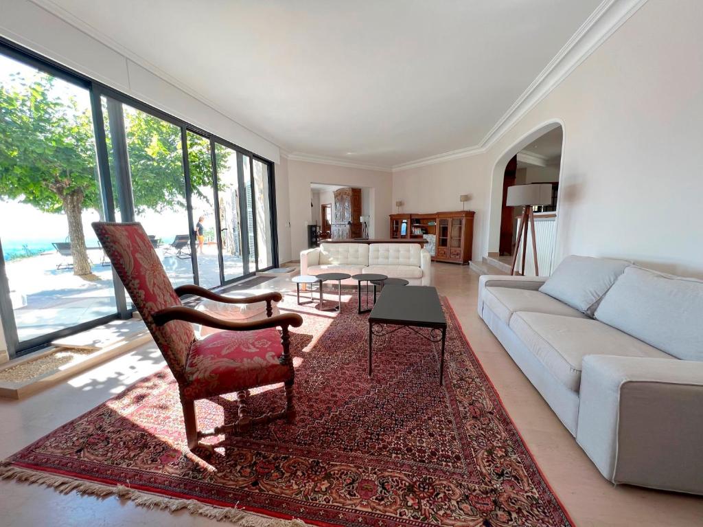 a living room with a couch and a chair at Bienvenue au Mas du Roulier, villa provençale avec vue hypnotique sur la chaine des Puys in Thiers