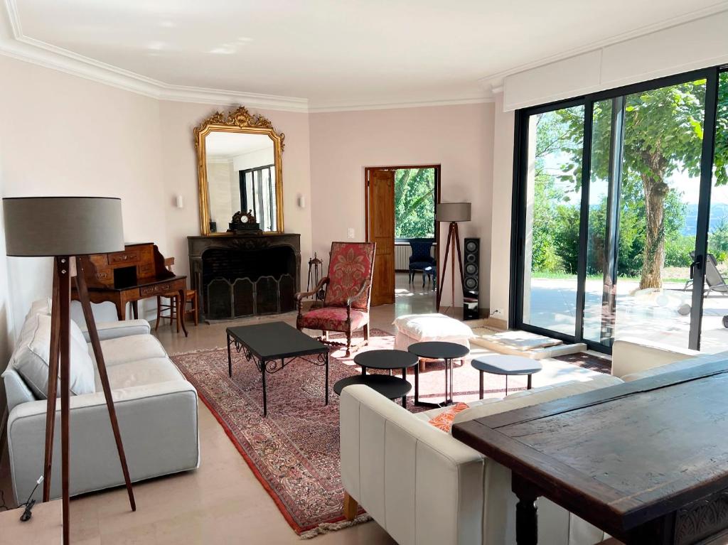 a living room with white furniture and a mirror at Bienvenue au Mas du Roulier, villa provençale avec vue hypnotique sur la chaine des Puys in Thiers