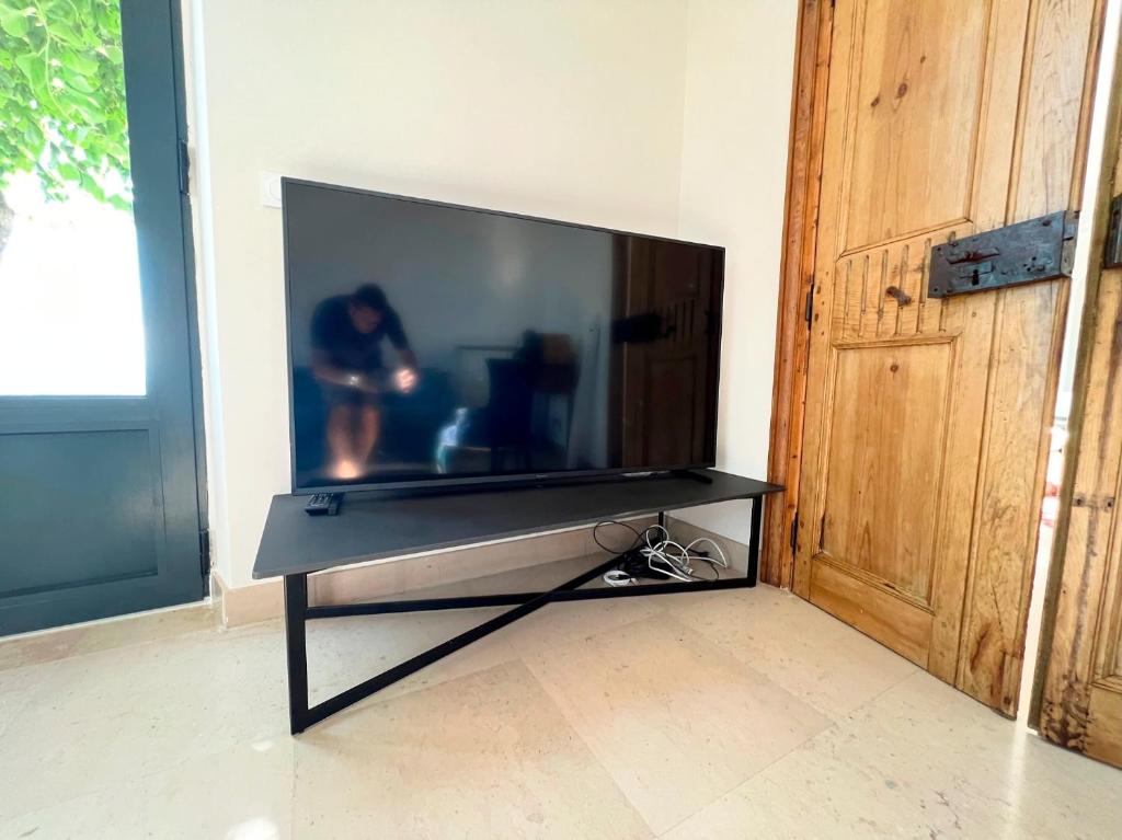 a flat screen tv sitting on a stand in a room at Bienvenue au Mas du Roulier, villa provençale avec vue hypnotique sur la chaine des Puys in Thiers