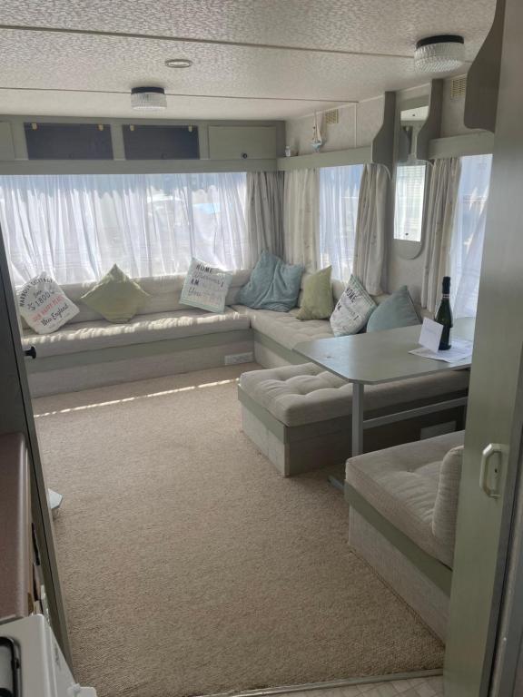 a living room with couches and a table in a van at Hollie’s Hemsby holidays - static caravan in Hemsby