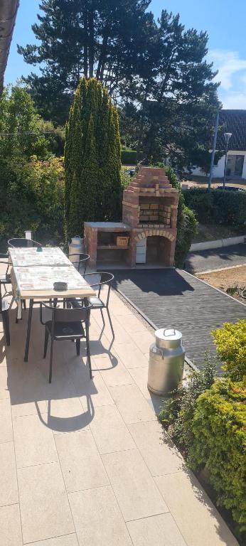 a patio with a picnic table and a grill at LE GALOPIN Etaples le Touquet in Étaples
