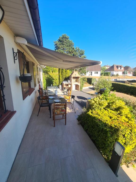 a patio with a table and chairs under an umbrella at LE GALOPIN Etaples le Touquet in Étaples
