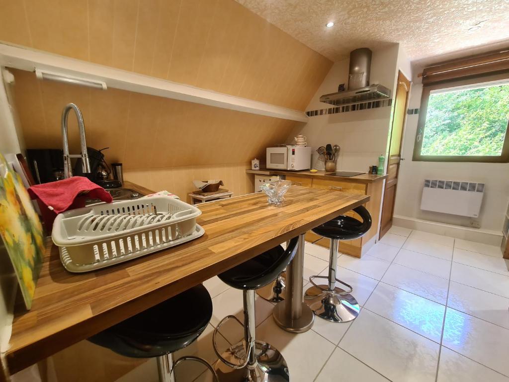 a kitchen with a wooden counter with stools in it at LE GALOPIN Etaples le Touquet in Étaples