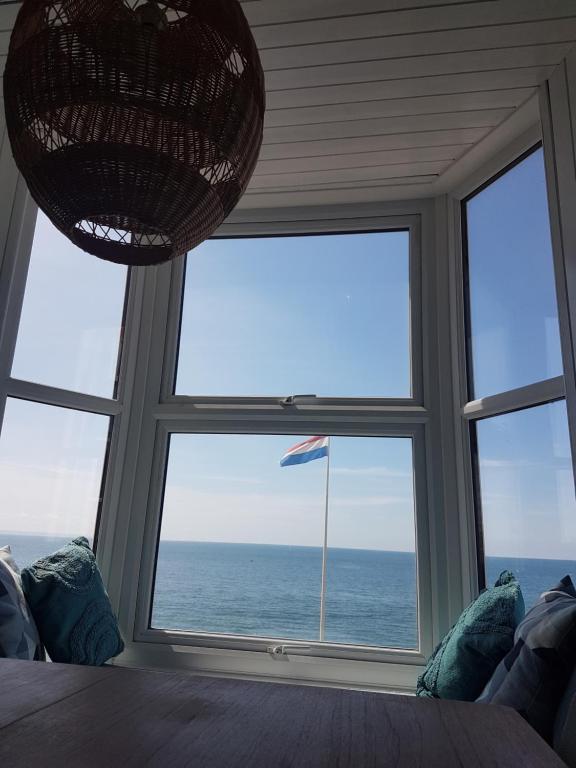 a room with a large window with a view of the ocean at Lovely Seafront 2 bed flat in Aberystwyth in Aberystwyth