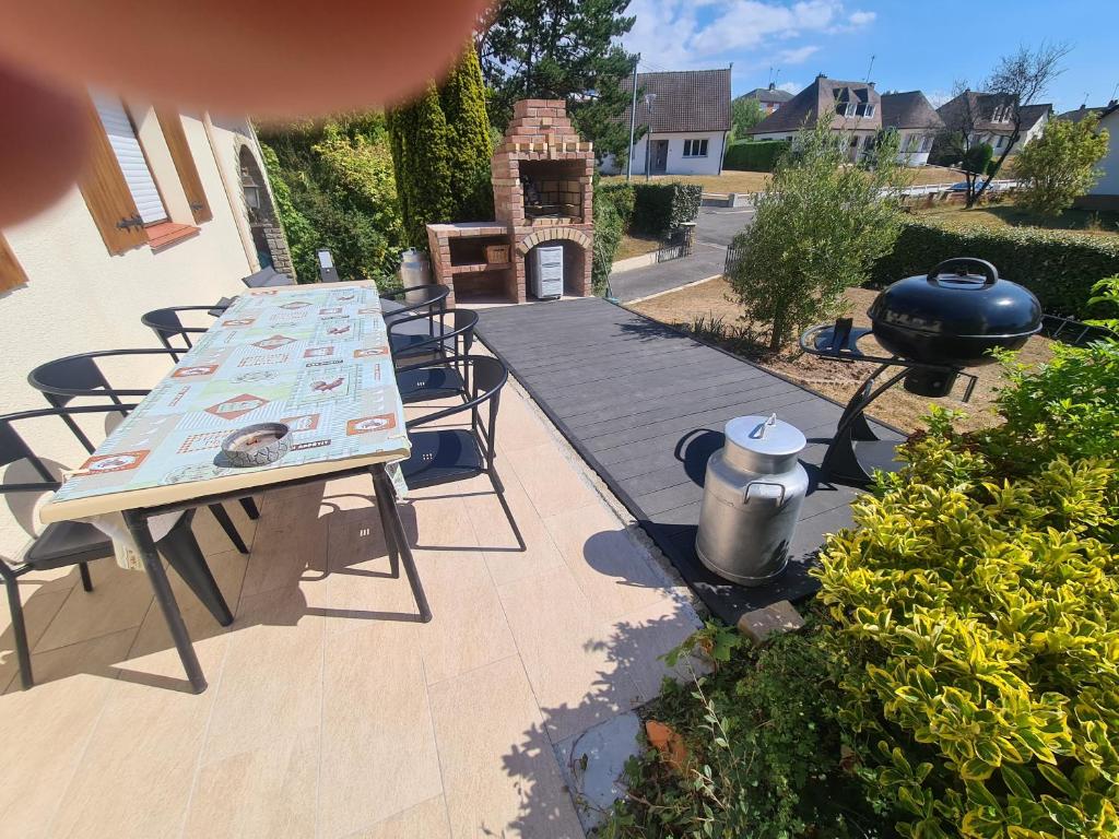 a patio with a table and chairs and a grill at LE GALOPIN Etaples le Touquet in Étaples