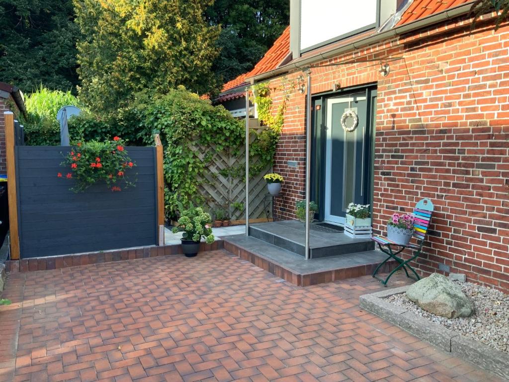 una casa de ladrillo con una puerta negra y un patio de ladrillo en FeWo "Zwischen den Meeren" en Rendsburg
