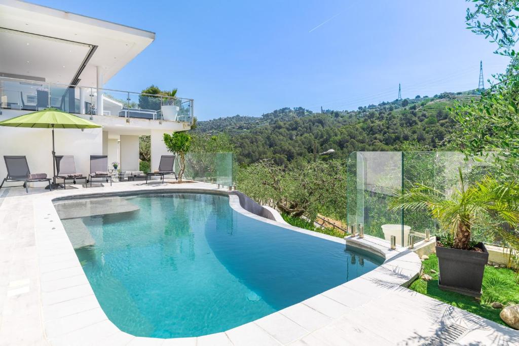 a swimming pool in front of a house at Villa des Oliviers in Nice