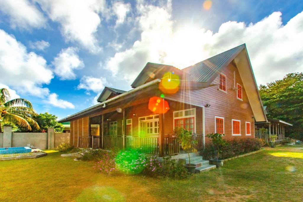 een huis met de zon erop bij Ambiance Villa in La Digue