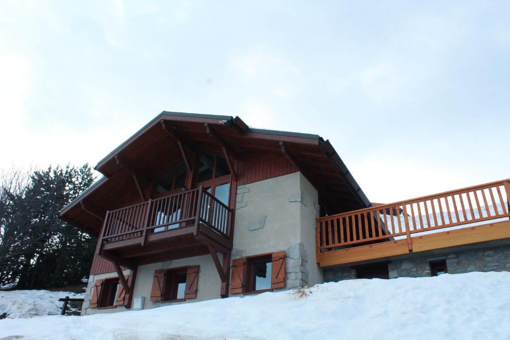 艾姆拉普拉涅的住宿－Chalet La Plagne Montalbert Pied des Pistes，一座带阳台的雪地建筑