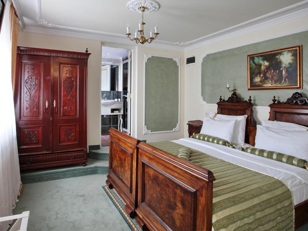 Postel nebo postele na pokoji v ubytování Queen's Astoria Design Hotel