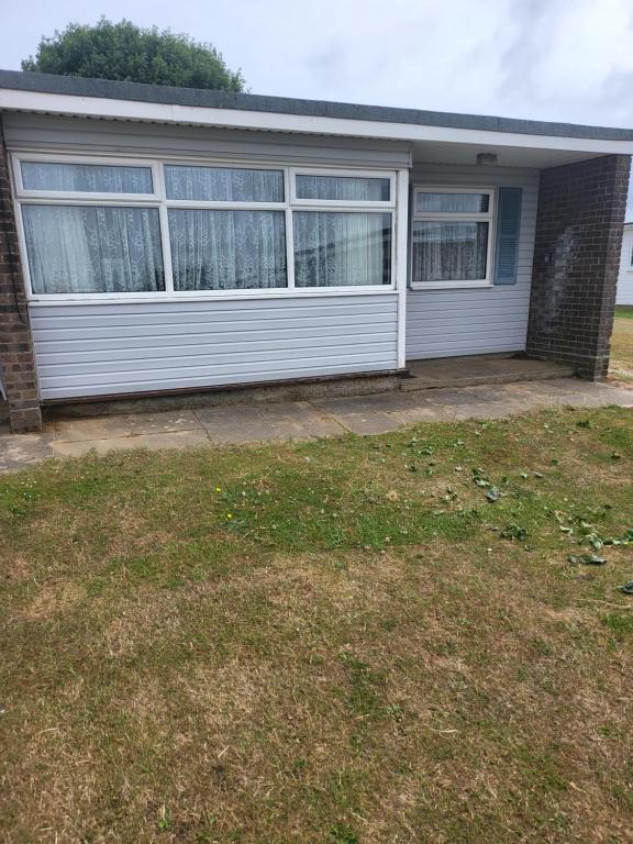 a white house with windows and a yard at The Bobbers in Great Yarmouth