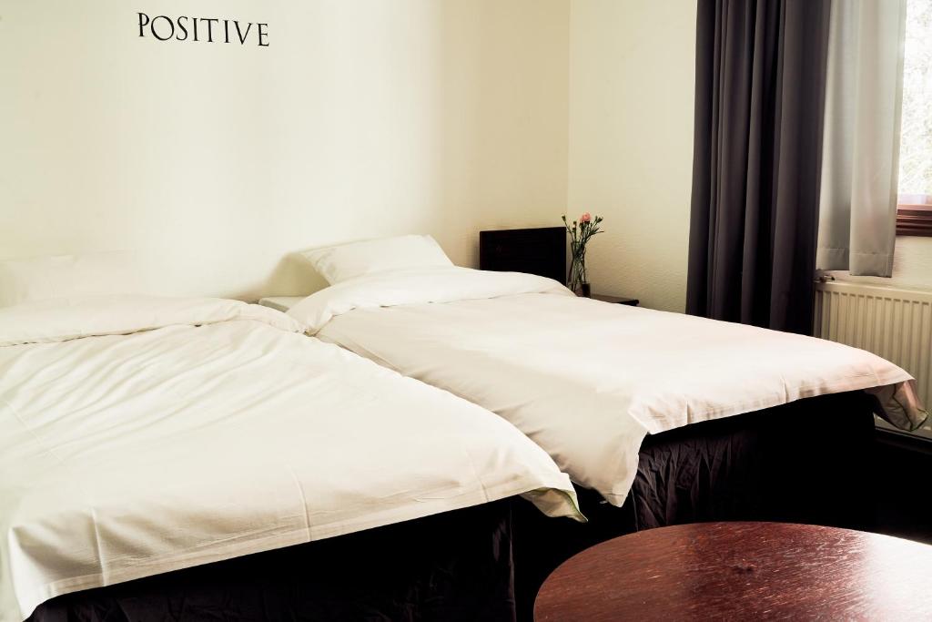 Duas camas sentadas uma ao lado da outra num quarto em Hotelli Havu em Uusikaupunki