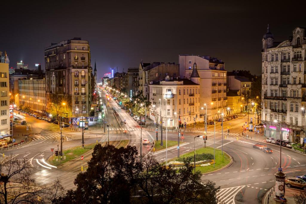 una calle de la ciudad por la noche con semáforos y edificios en Planet Hostel en Varsovia