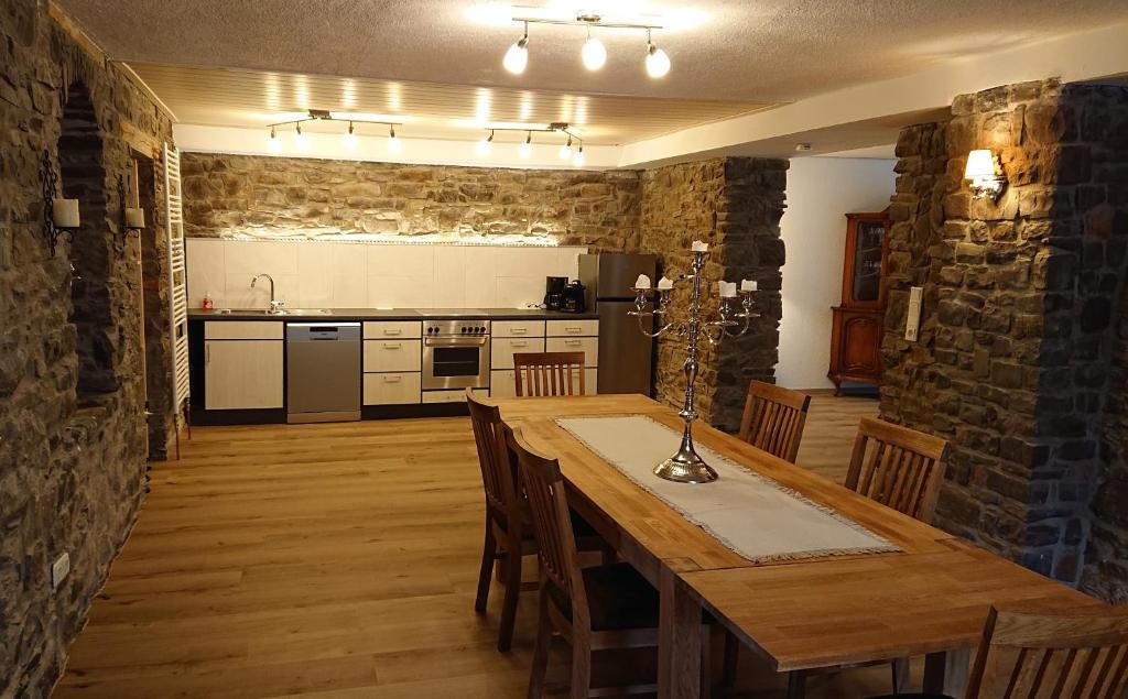 Schmugglerhaus : مطبخ وغرفة طعام مع طاولة وكراسي خشبية