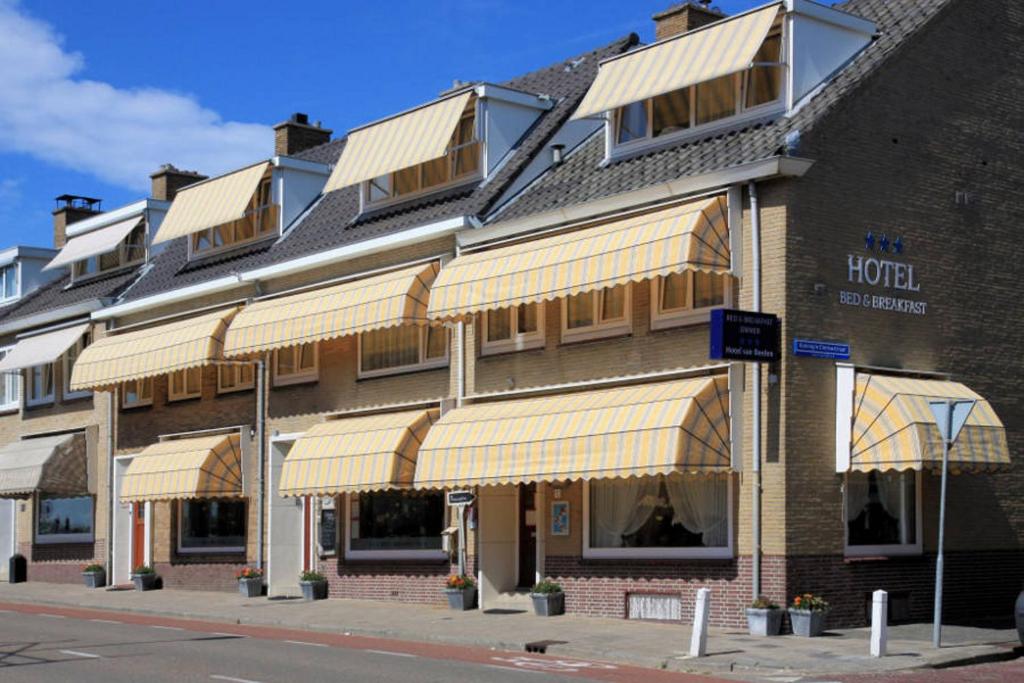 un edificio de hotel con una fila de toldos en él en Sleeping by Van Beelen, en Katwijk