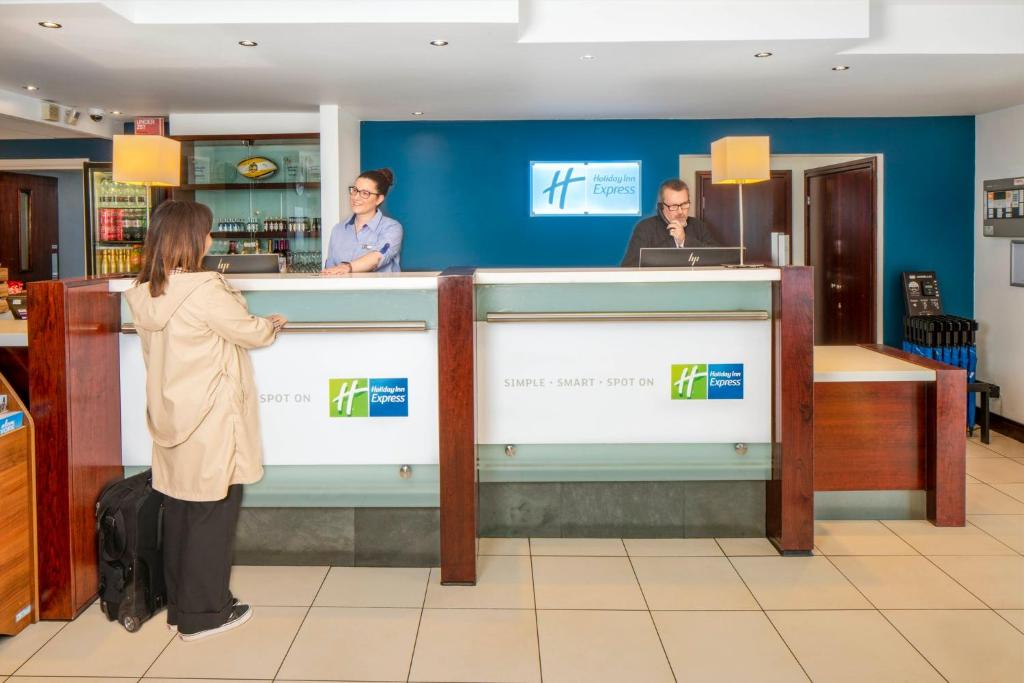a woman standing at a cash counter in a store at Holiday Inn Express York, an IHG Hotel in York