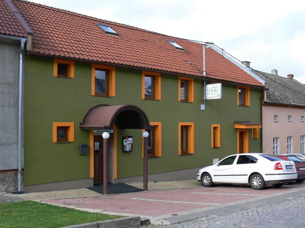 a green building with a car parked in front of it at Penzion Mata in Malenovice