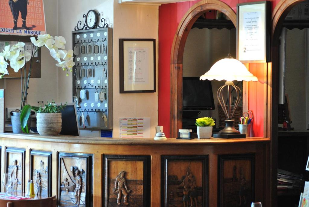 a room with a counter with pictures on it at Hotel Les Voyageurs in Les Sables-d'Olonne