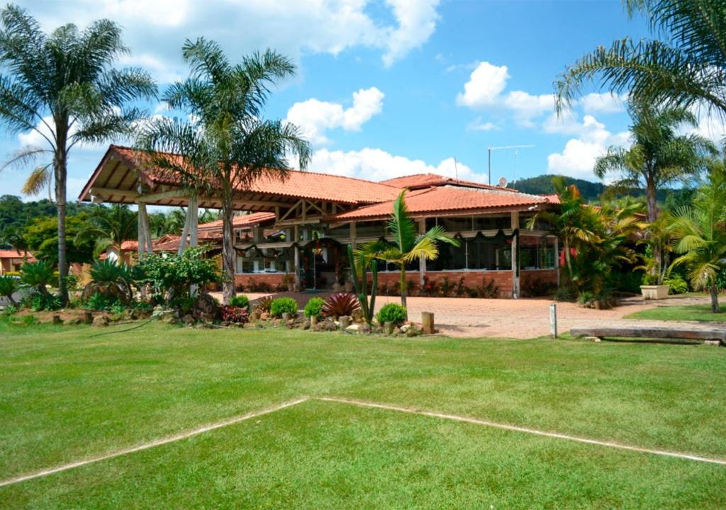 uma casa com um relvado verde em frente em Hotel Fazenda Hípica Atibaia em Atibaia
