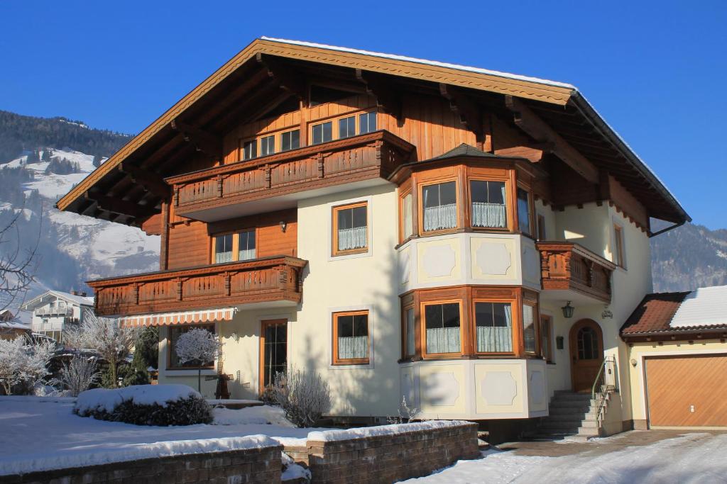 a large house with a wooden roof in the snow at Haus Schönegger in Dorfgastein