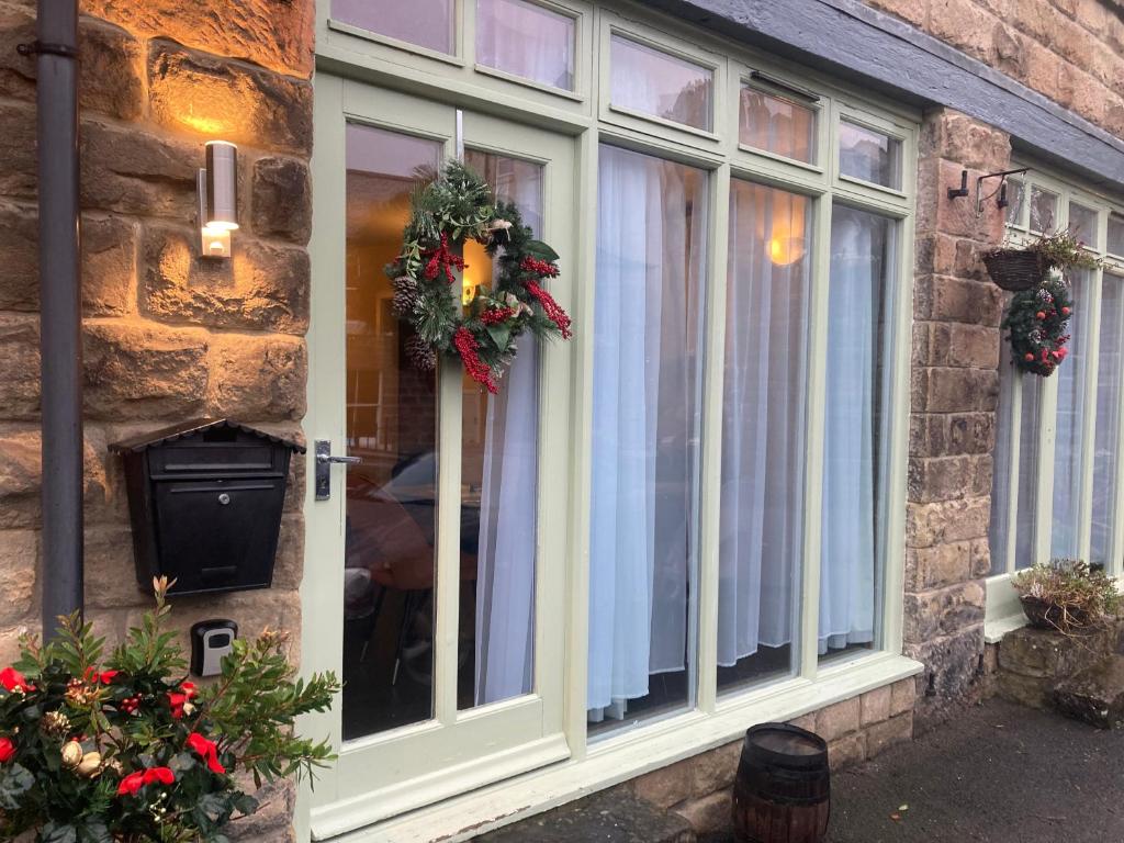 a window with christmas wreaths on it at 1 Coach House Mews - Matlock Bath in Matlock Bank