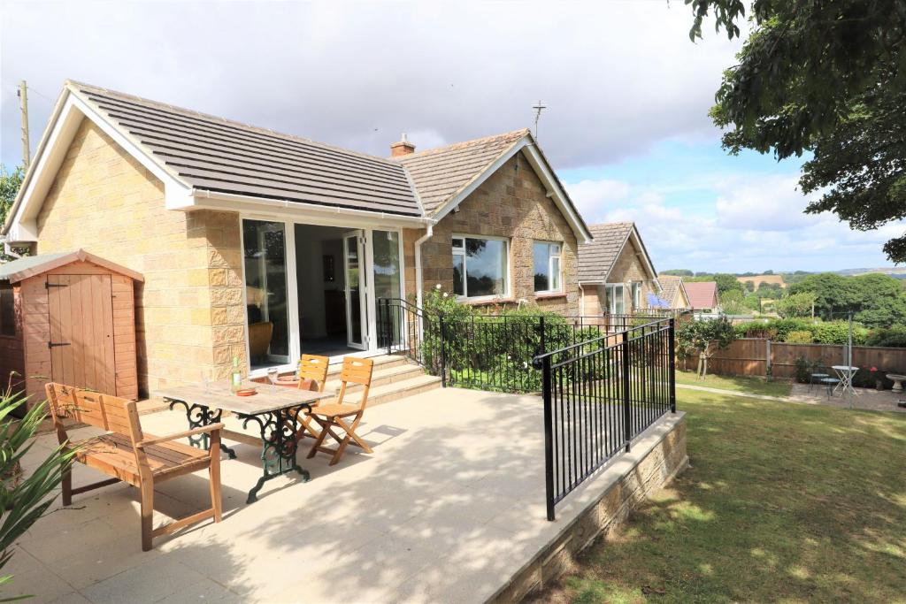a house with a patio with a table and chairs at Hilltops in Wroxall