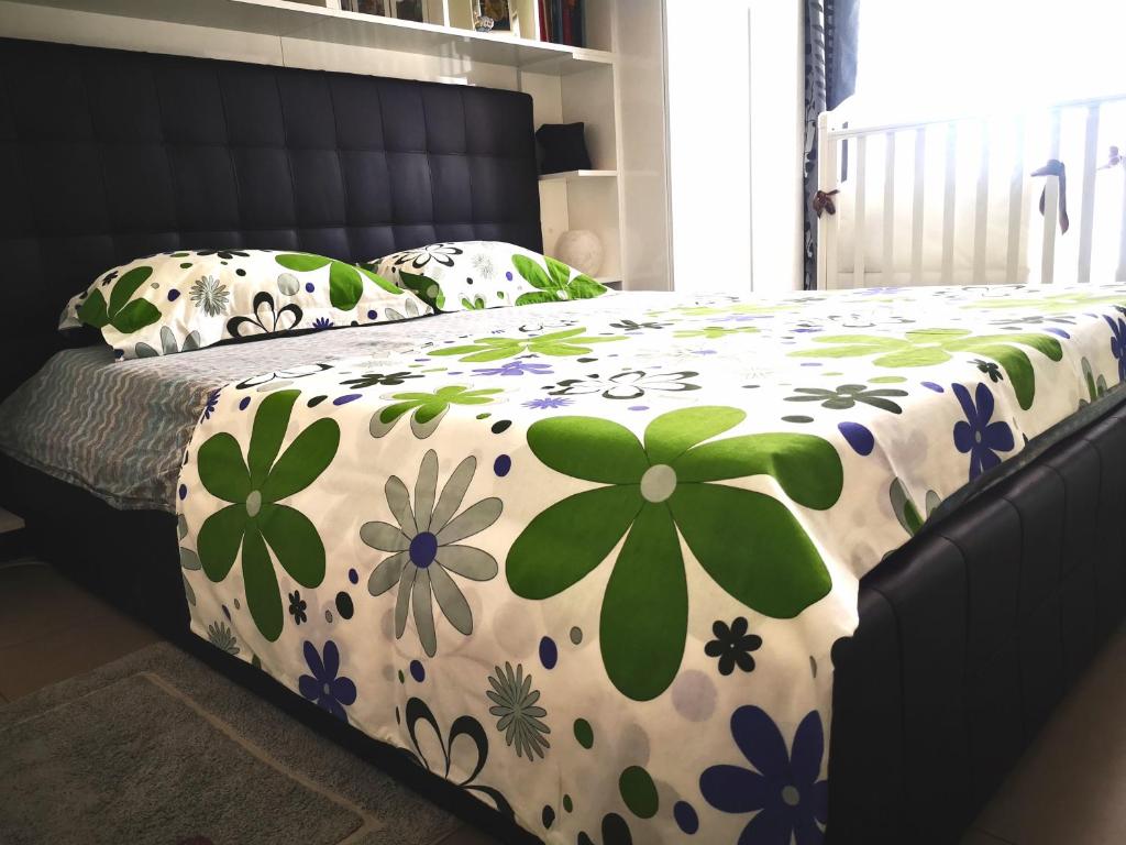 Una cama con una manta con flores. en Delizioso appartamento nel cuore Castelli Romani en Marino