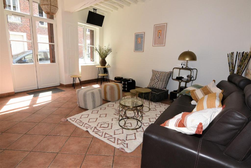 a living room with a leather couch and a table at Les Falaises de l'Estran in Dieppe