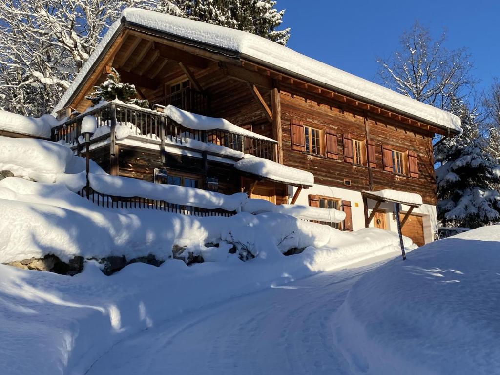Cabaña de madera cubierta de nieve con entrada en Chalet Tschengla, en Bürserberg