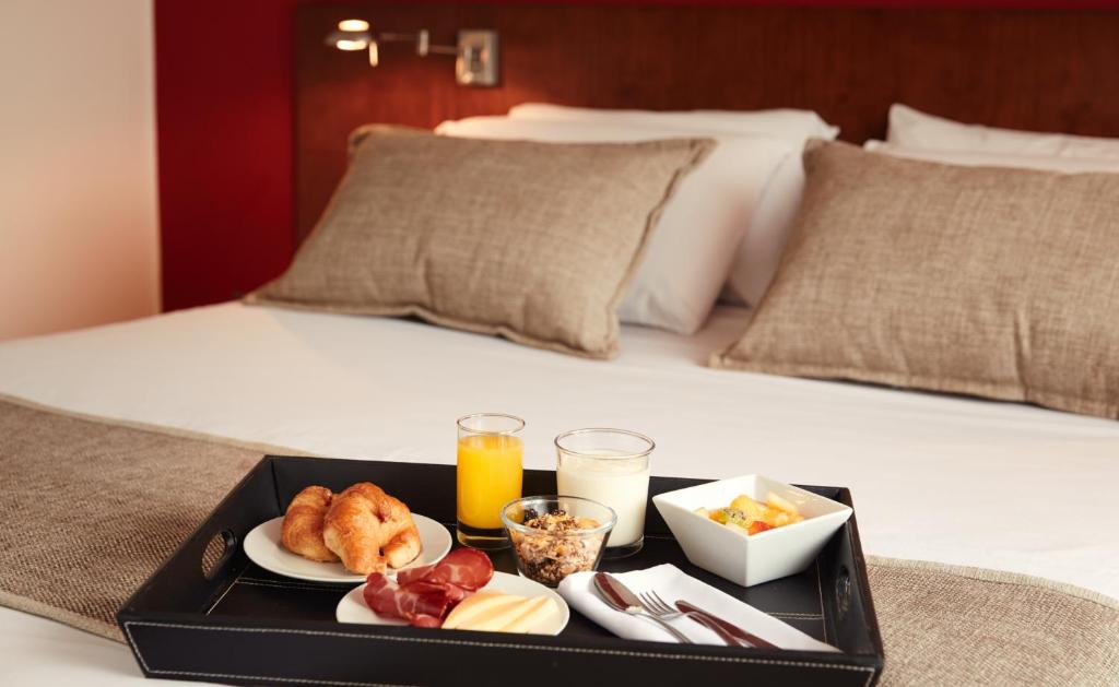 a tray with breakfast foods on a bed at Gran Hotel Paysandú in Paysandú