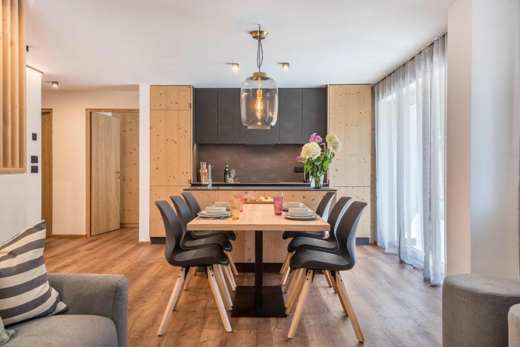 una cucina e una sala da pranzo con tavolo e sedie in legno di Apartement Franzl a San Vigilio Di Marebbe