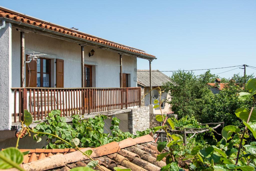 ein Haus mit einem Gemüsegarten davor in der Unterkunft Apartma Na skdnu in Dutovlje