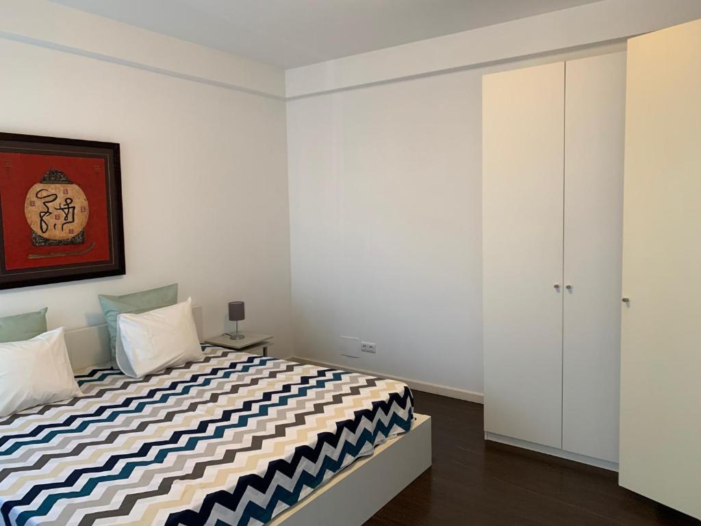 a bedroom with a bed with a black and white comforter at Charming apartment in Principle Real in Lisbon